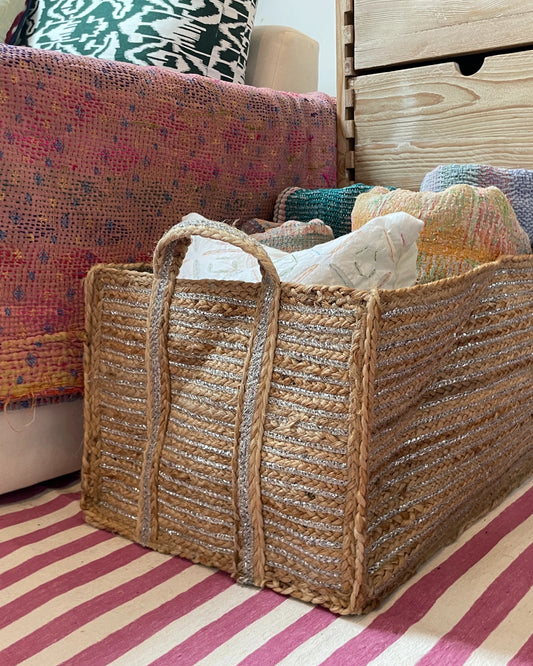 Close up of braided silver and jute blanket basket in a bright and colourful interior