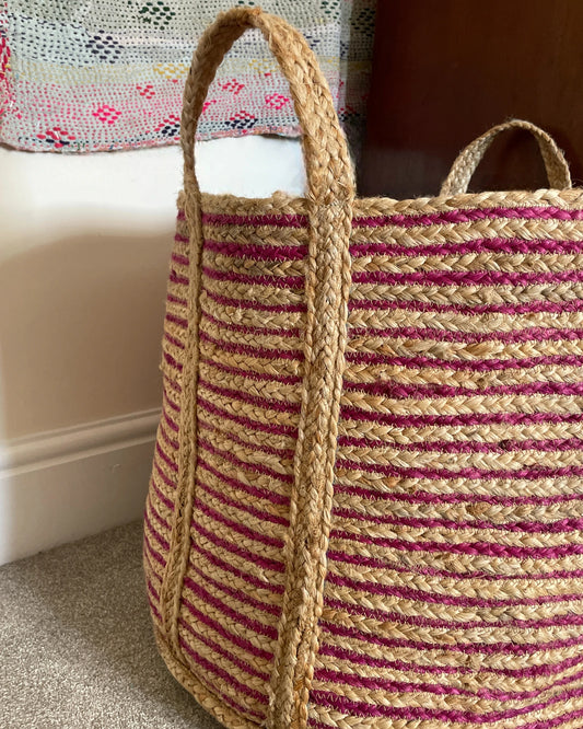 Close up image of the braided woven jute basket in deep pink and natural jute with plain handles