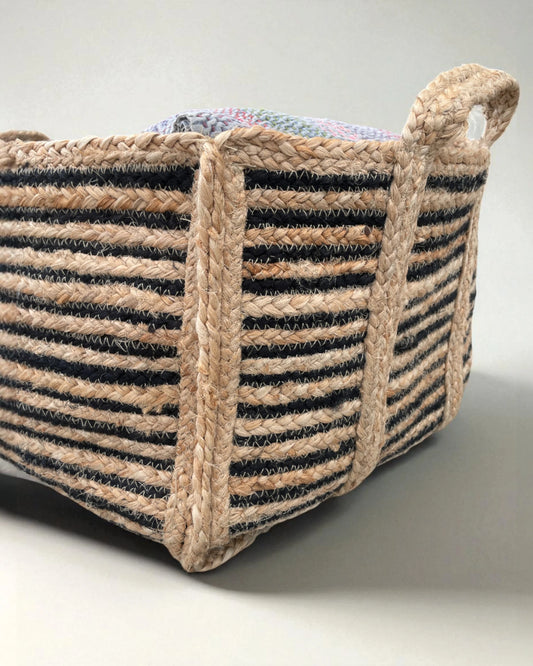 close up of detail of black and natural woven braided storage basket with two handles