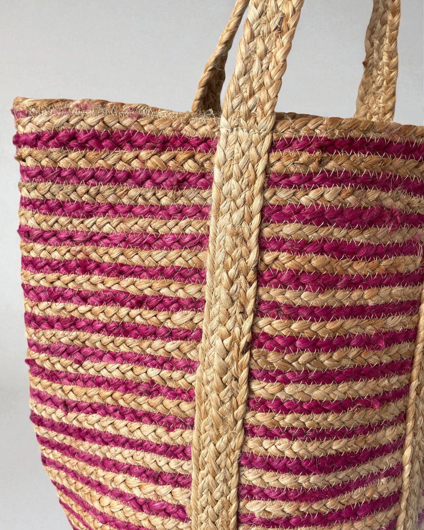 close up detail of hand braided pink and natural open bag