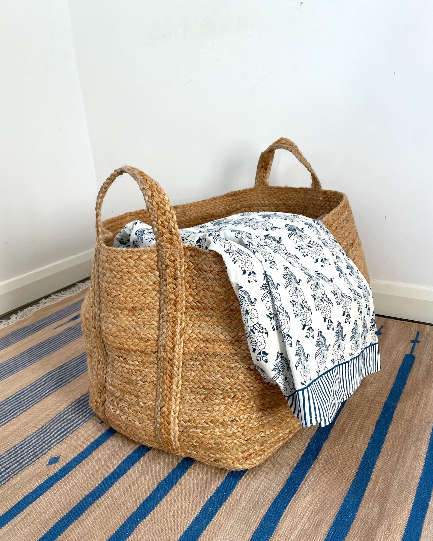 Woven blanket or laundry basket suitable for storing textiles and soft furnishings in the home