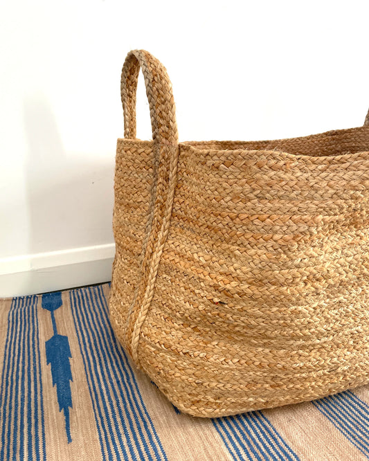close up of large natural light jute storage basket with two handles