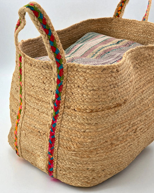 detail of woven seagrass basket with bright cotton handles