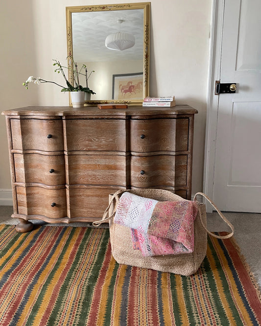 Sisal storage basket holding a folded textured blanket for stylish home organisation
