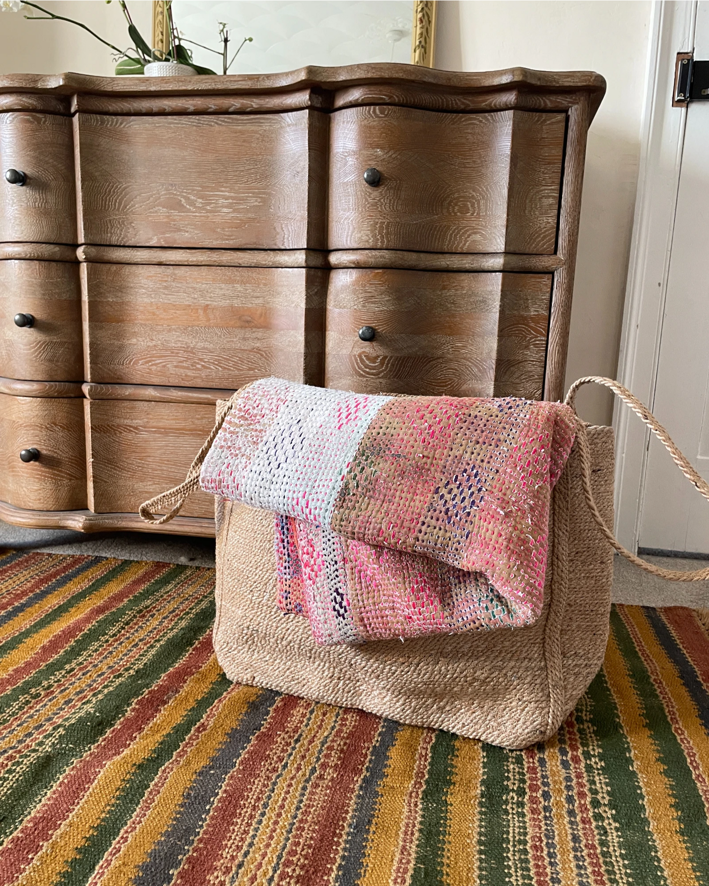 Handwoven sisal blanket basket styled in a living room for throws and soft furnishings