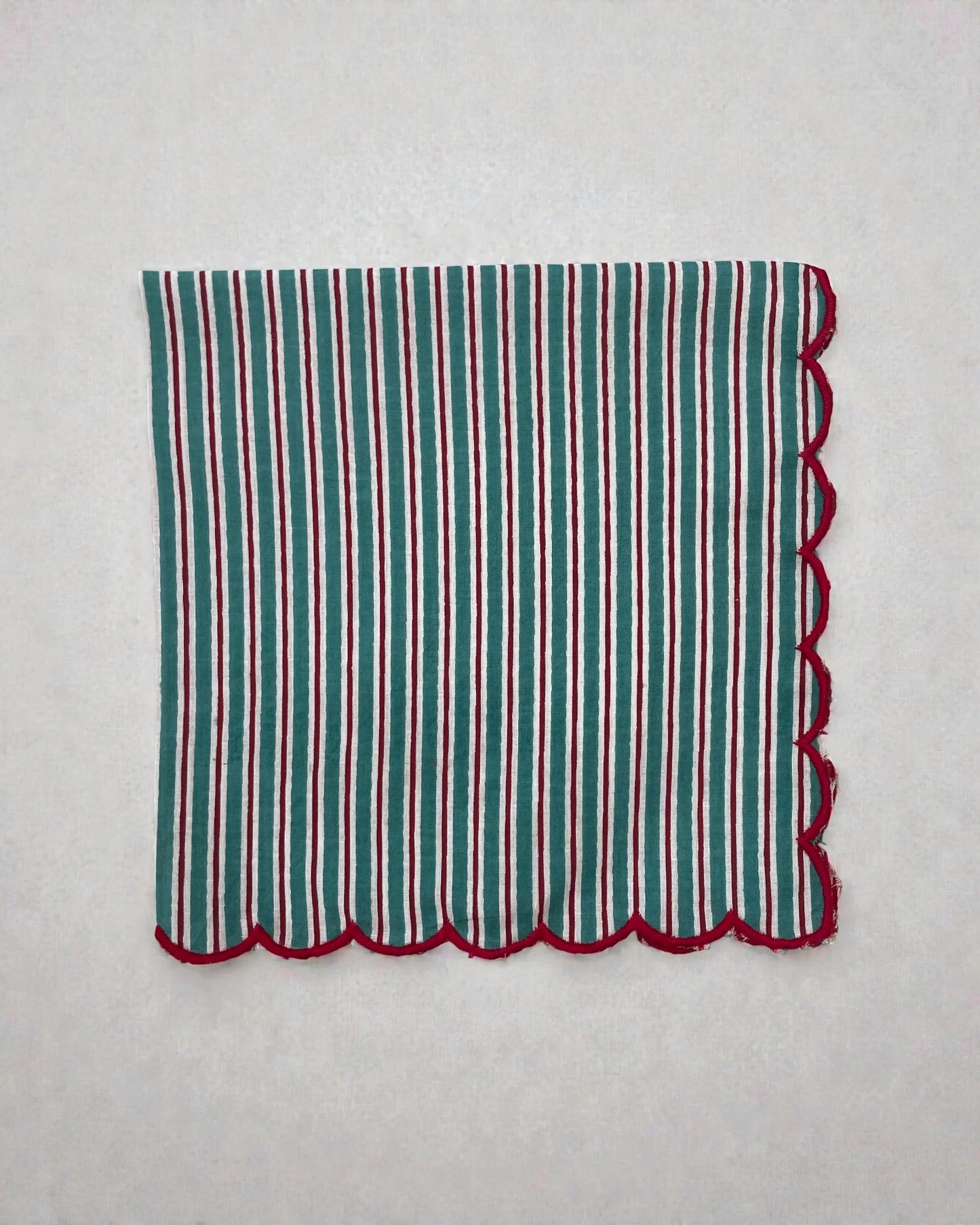 Cotton table napkin with teal stripes and scalloped red border