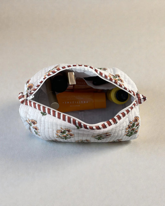 Quilted cotton makeup bags with delicate floral print on white fabric and contrasting striped zip trim