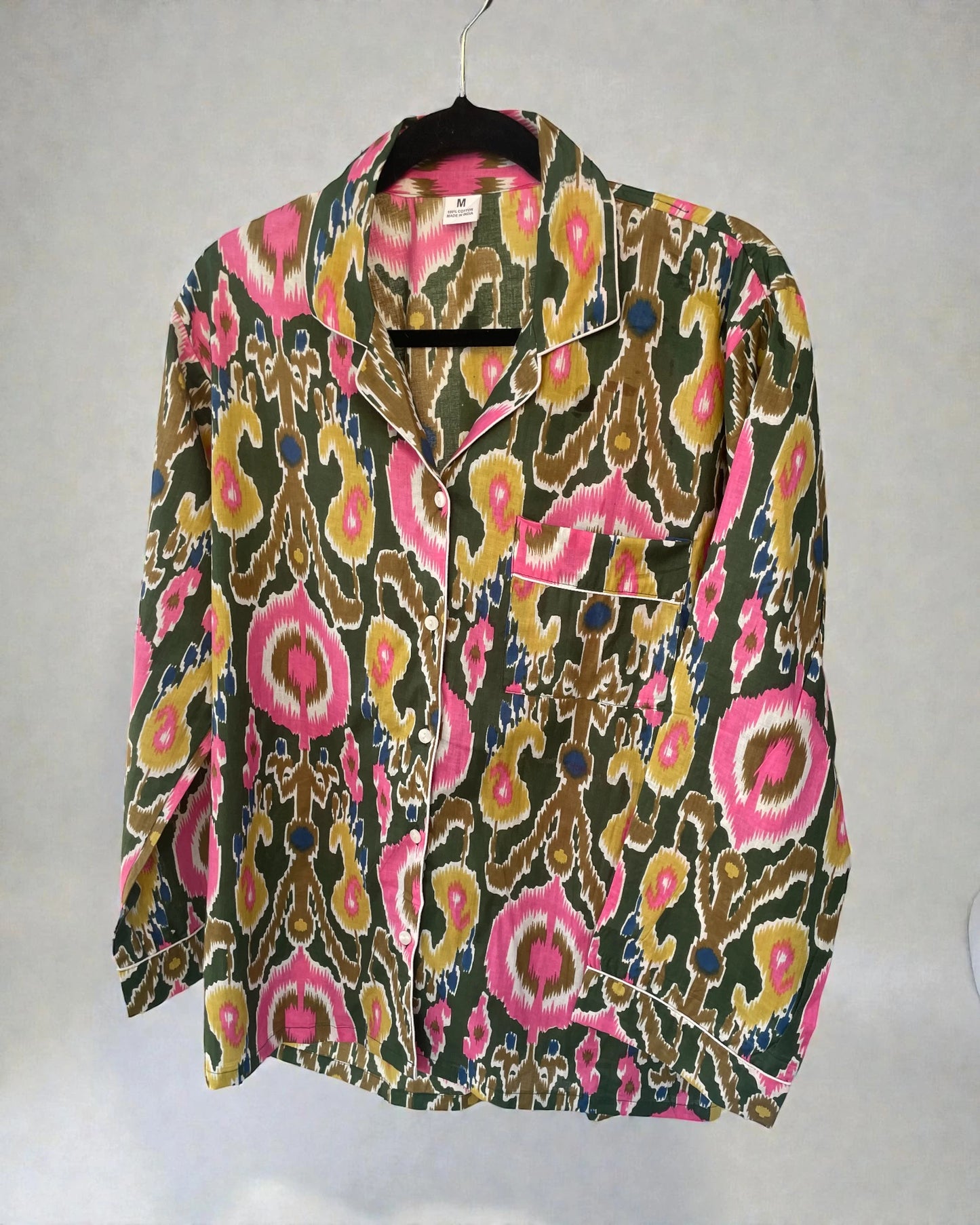 Close up of green and pink ikat printed cotton fabric on women’s pyjamas