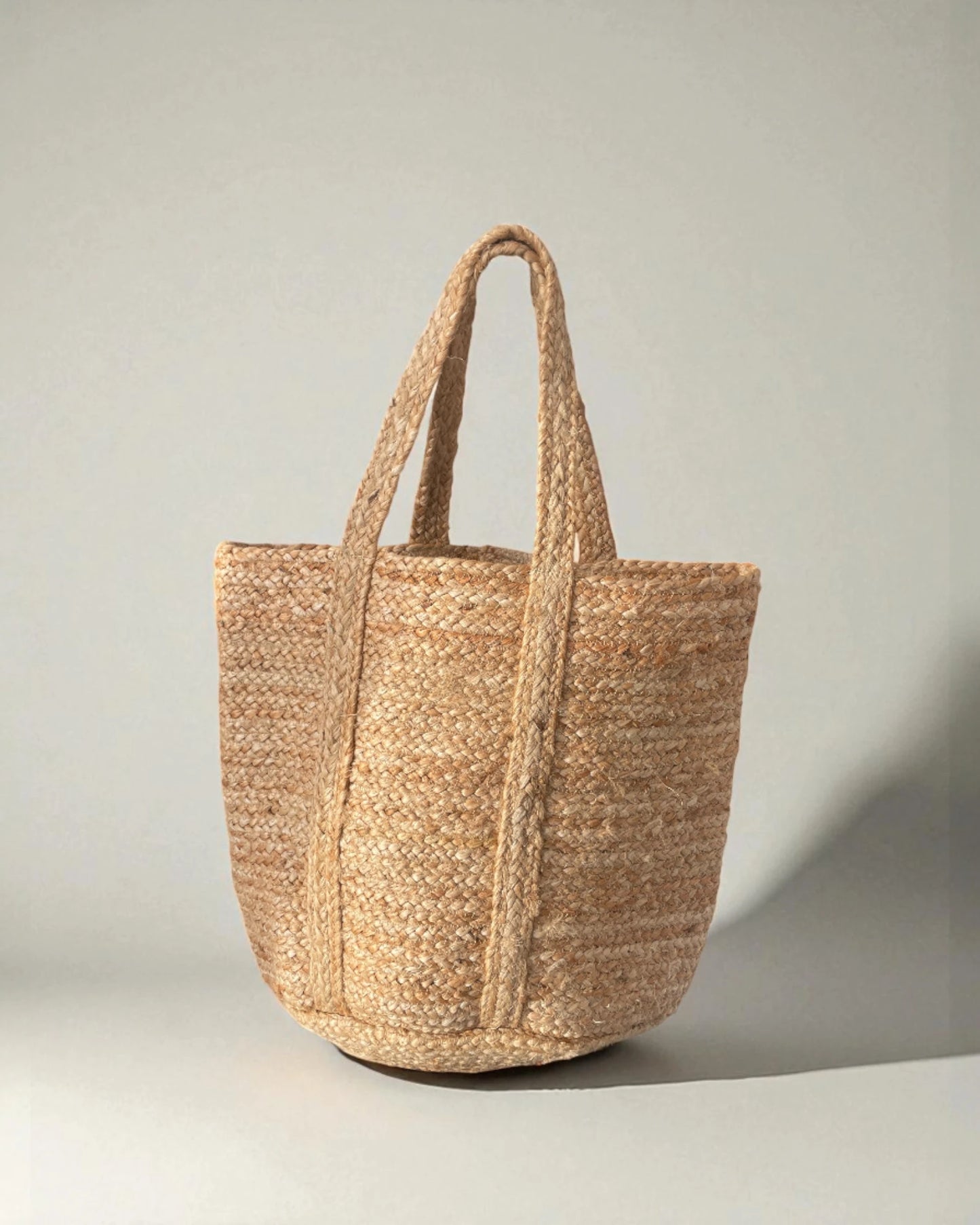 Woven straw tote bag on a light gray background