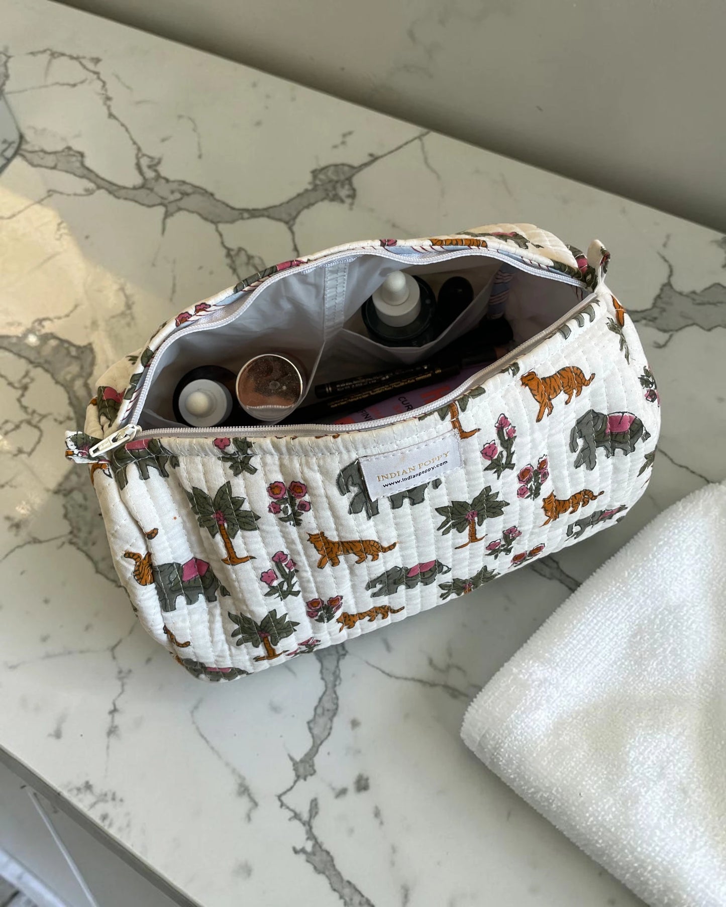 Animal print cosmetics wash bag in a luxury bathroom, stylish toiletry pouch for makeup and travel essentials displayed on an elegant vanity showing use for cosmetics