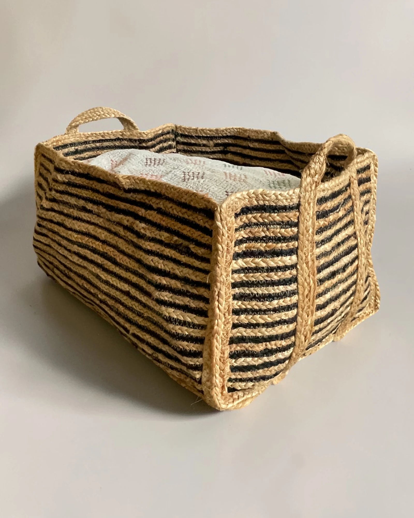 Striped jute basket used for shoe storage in hallway