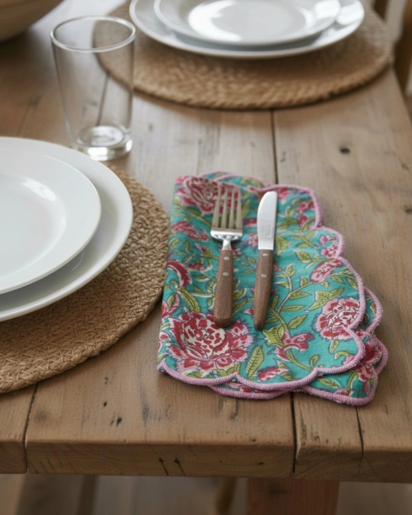 Blue floral block print cotton napkin with contrasting pink scalloped trim, perfect for elegant table settings