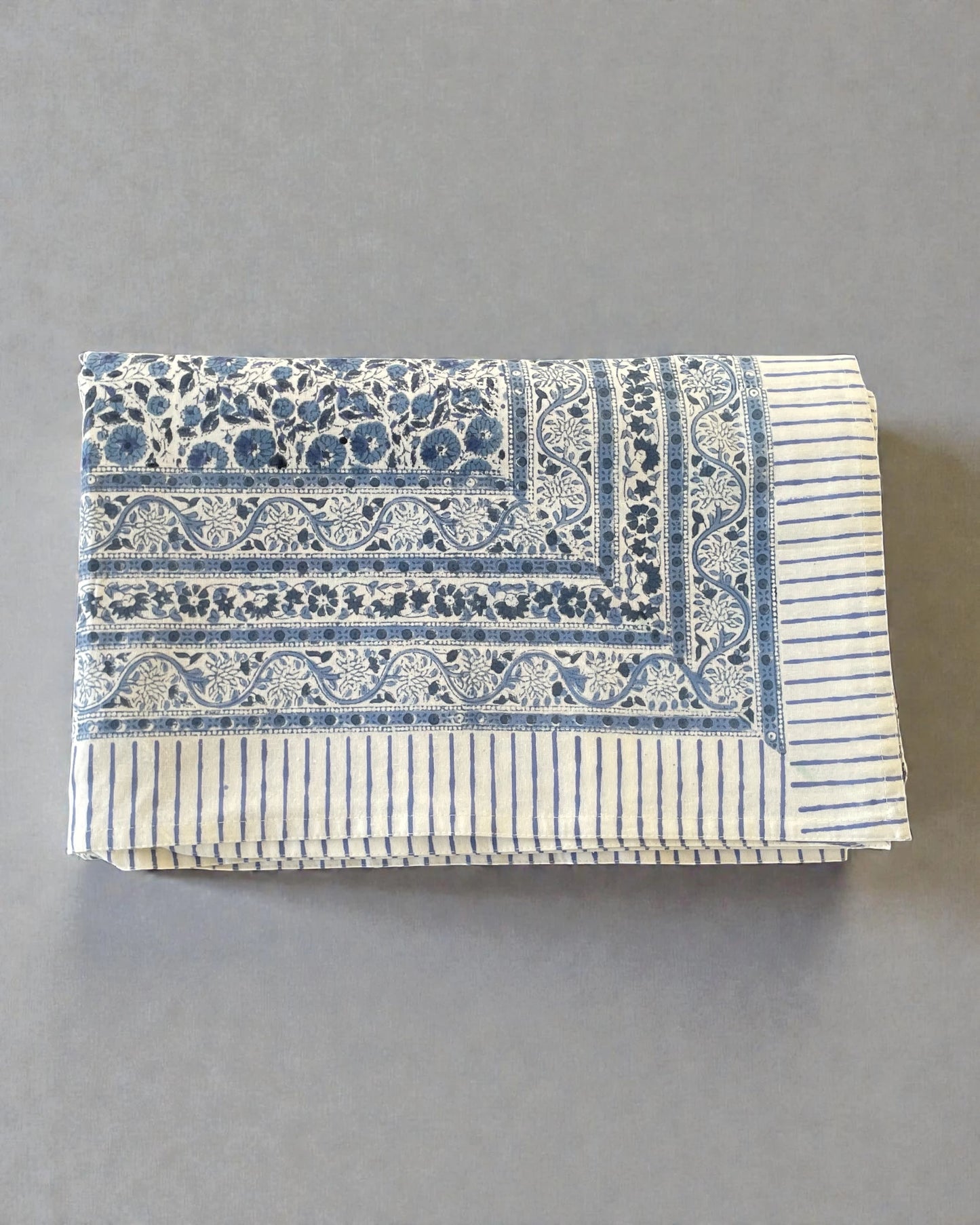 artisan blue and white tablecloth with floral border and striped hem detail