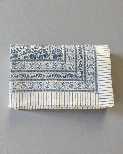 artisan blue and white tablecloth with floral border and striped hem detail