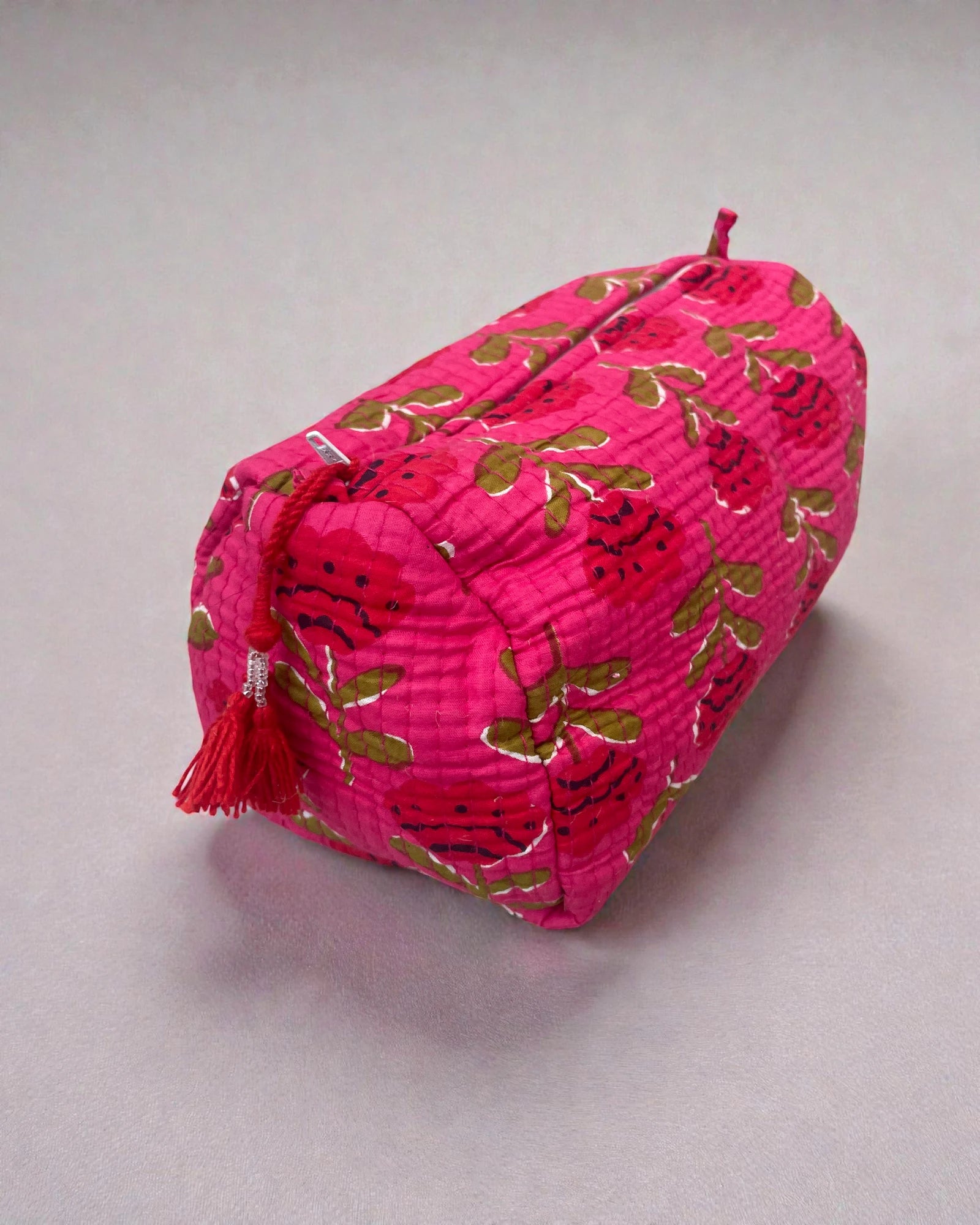 small, medium and large pink cosmetic bags with bold floral design and tassel zip pulls