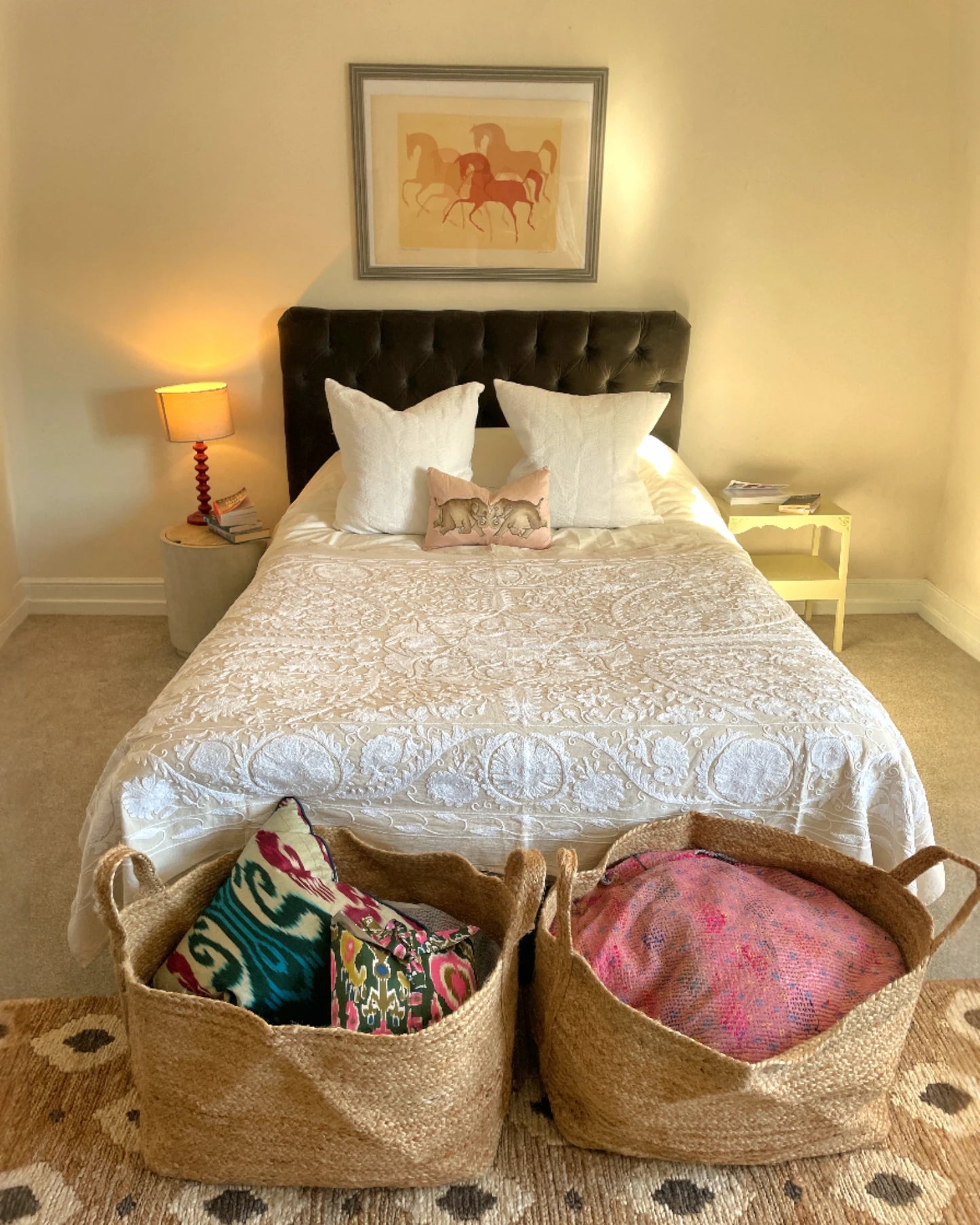 Neutral suzani quilt in ecru and white styled in a relaxed bedroom interior