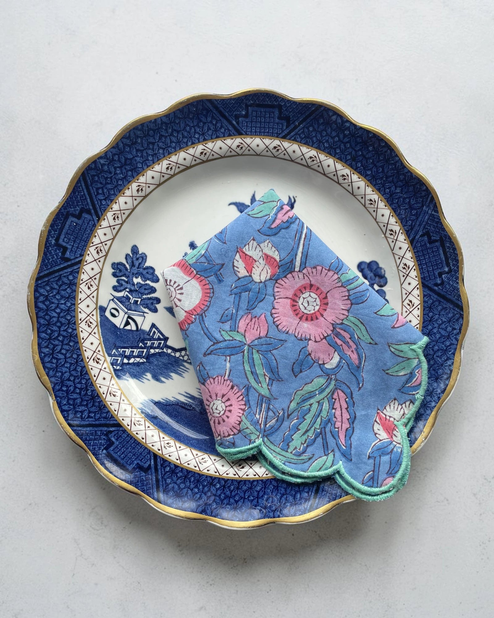 Pink floral cotton napkin set with scalloped edges and teal border, perfect for elegant table settings
