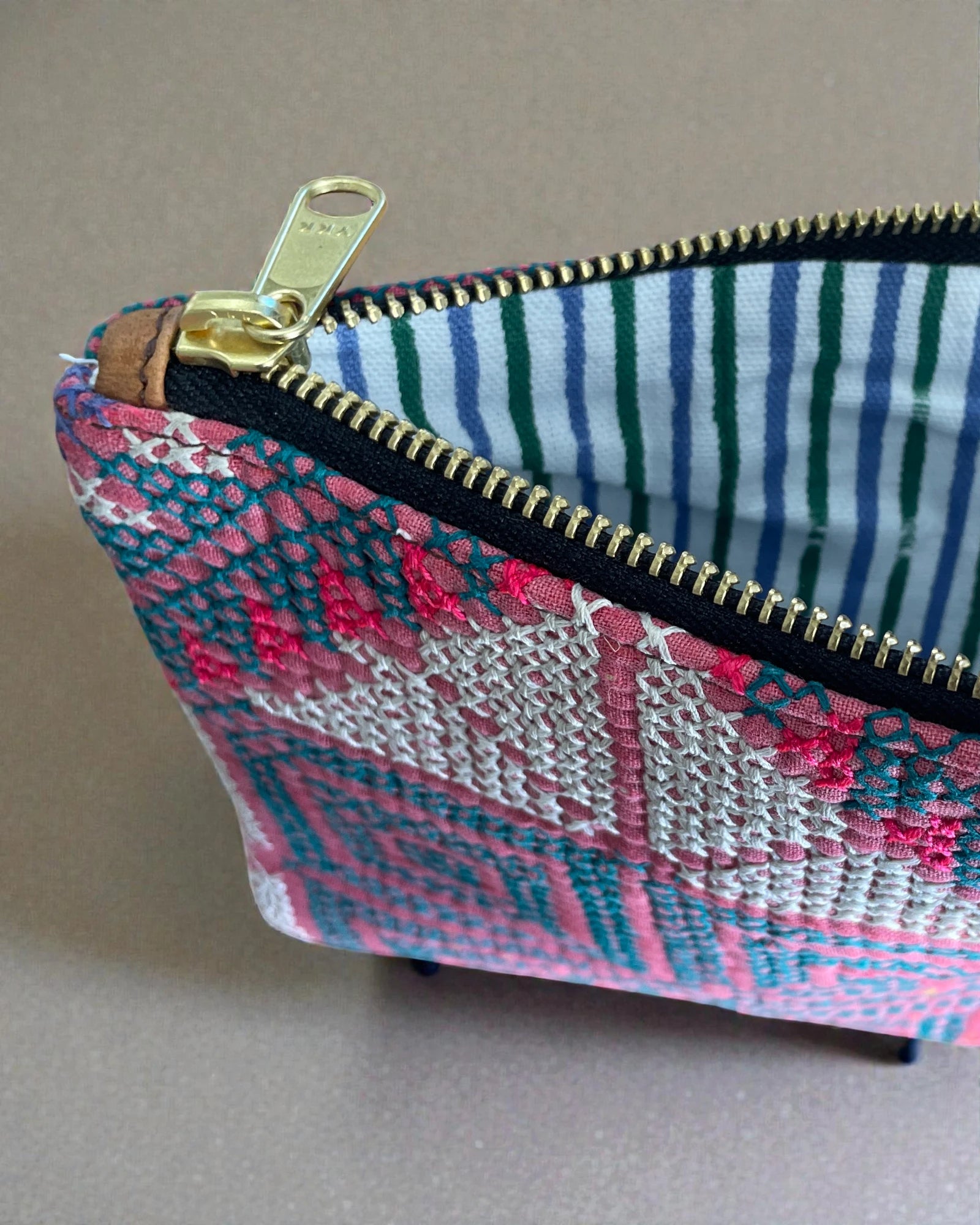 Boho-style cosmetic pouch with geometric embroidery and gold zipper