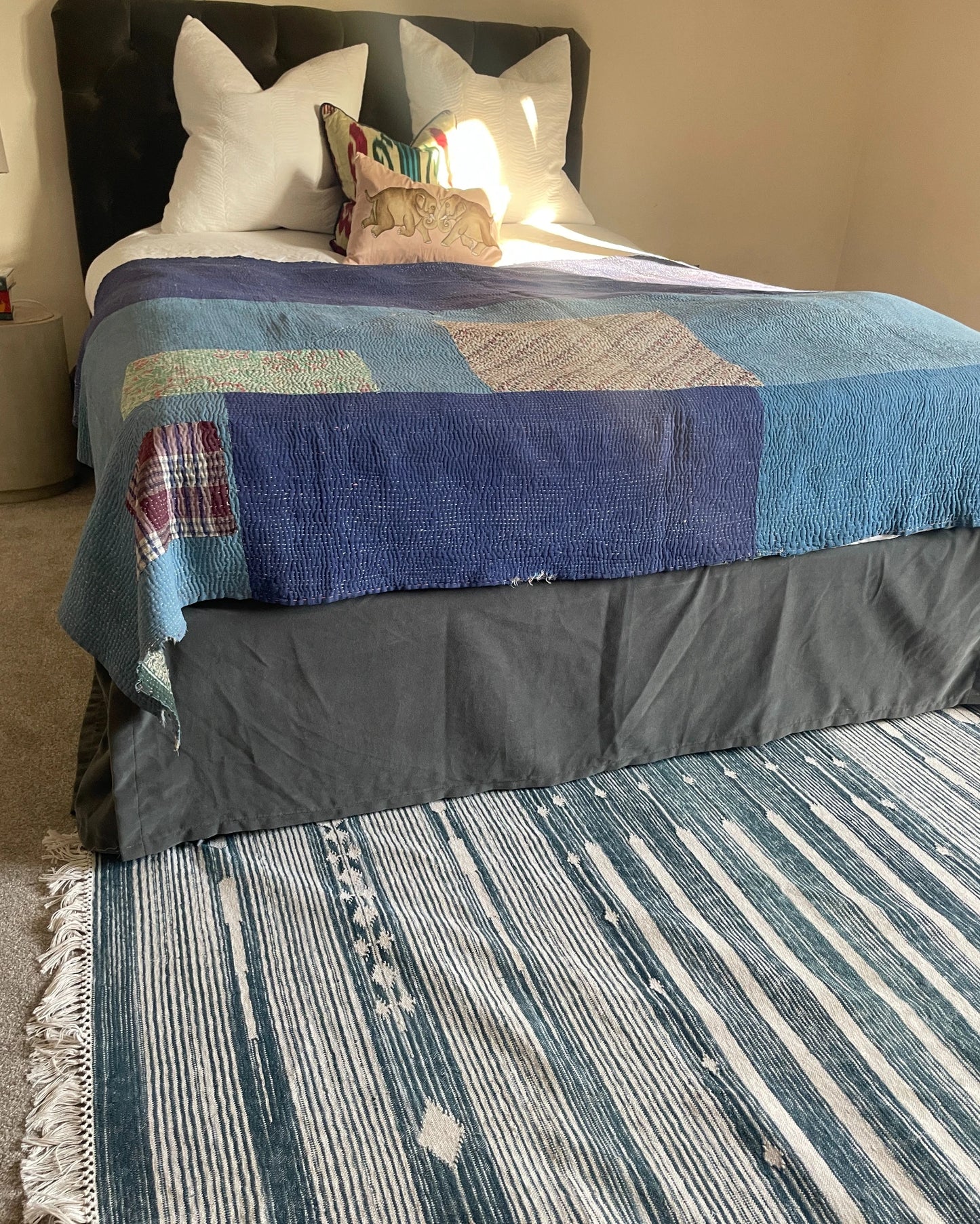 eclectic bedroom with blue rug and decorative bed