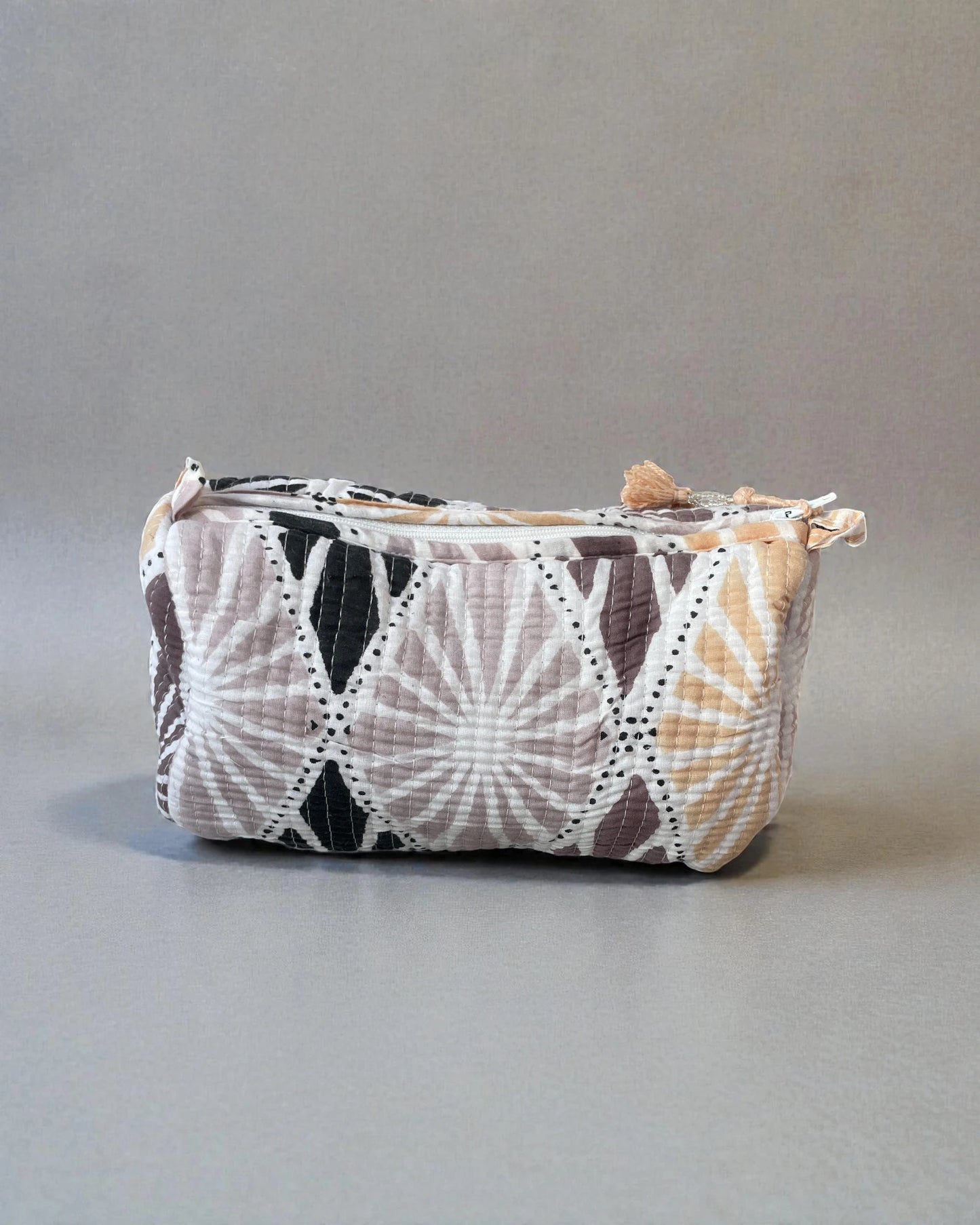 medium quilted cotton wash bag with pastel geometric shell motif on patterned tiles