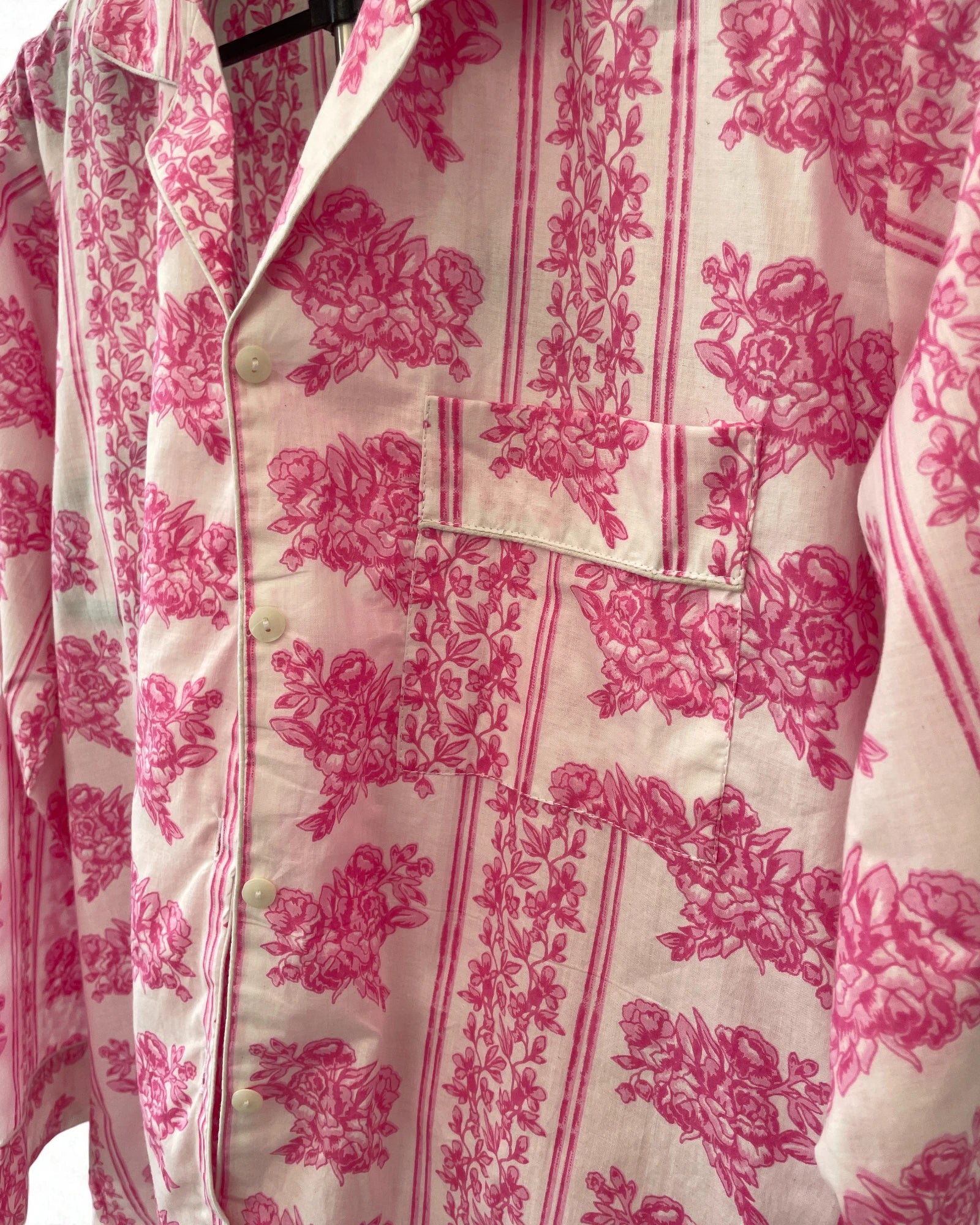 Close-up of pink floral cotton pyjama shirt with button front and striped border trim
