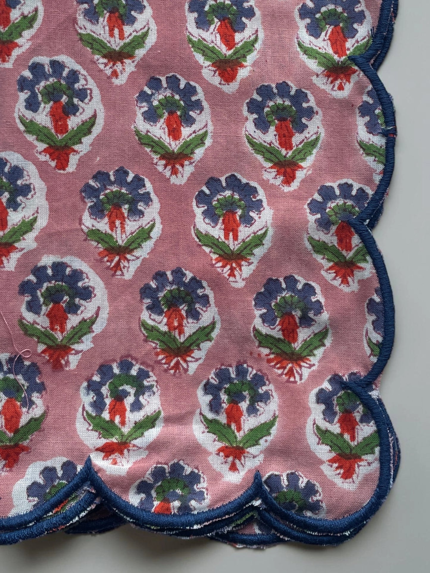 Set of six pink floral cotton napkins with scalloped edges and contrasting blue trim