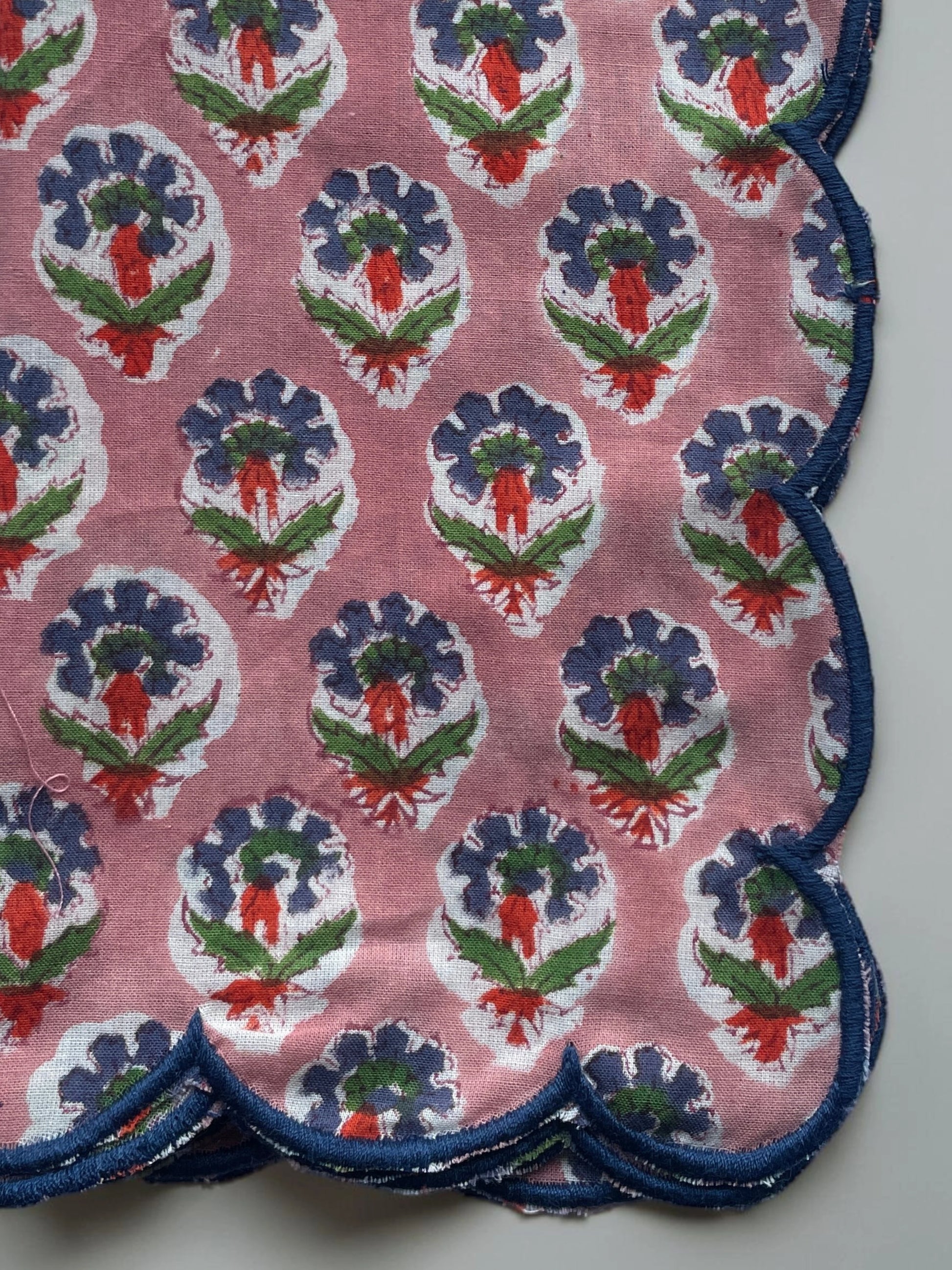 Set of six pink floral cotton napkins with scalloped edges and contrasting blue trim