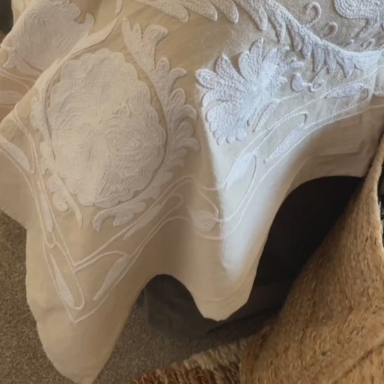 A beautifully hand stitched Suzani quilt in soft ecru and white, crafted on an off white linen base with intricate white embroidery. Designed to be styled as a king size bedspread or used as a statement sofa throw, this timeless piece brings texture, warmth and artisanal craftsmanship to any interior. Perfect for neutral bedrooms, relaxed living spaces and layered, collected homes