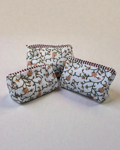 Set of three quilted cotton cosmetic bags with green floral block print, softly padded and water-resistant lined, stacked together.