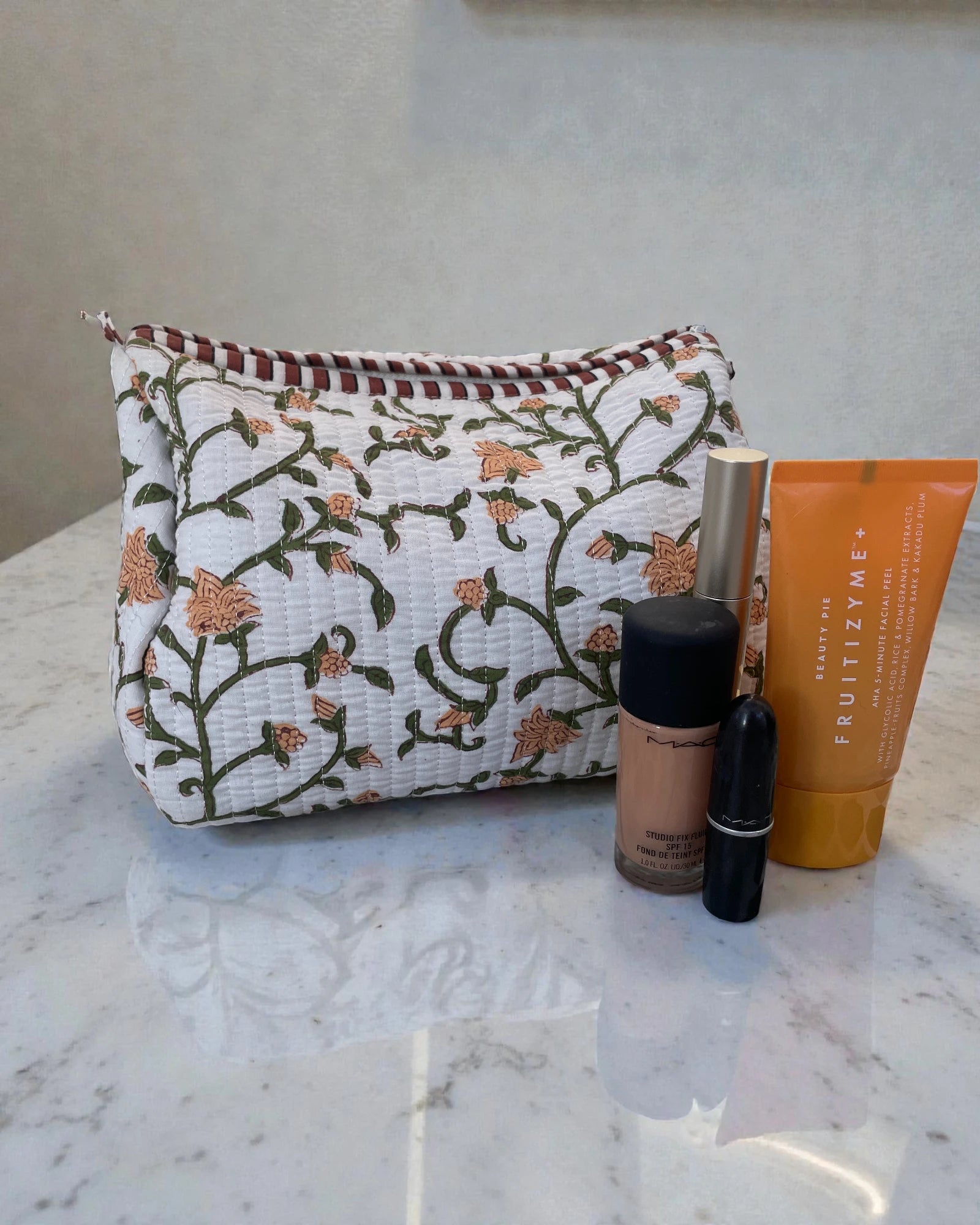 Quilted cotton toiletry bags with green and yellow floral print styled as a coordinated set, ideal for travel or bathroom storage.