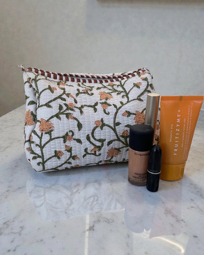 Quilted cotton toiletry bags with green and yellow floral print styled as a coordinated set, ideal for travel or bathroom storage.