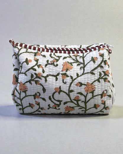 Quilted cotton toiletry bags with green floral print styled as a coordinated set, ideal for travel or bathroom storage.