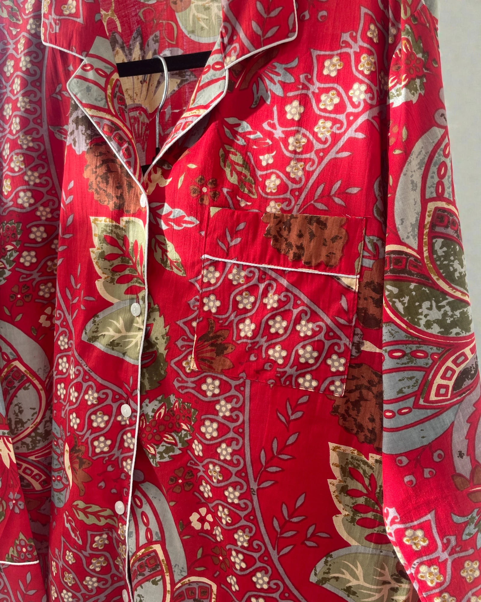 Detail of piped edging on scarlet red floral cotton pyjama set