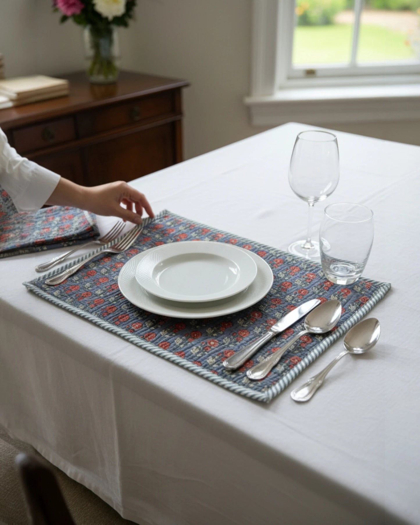 Quilted scarlet and grey cotton placemats layered over a tablecloth