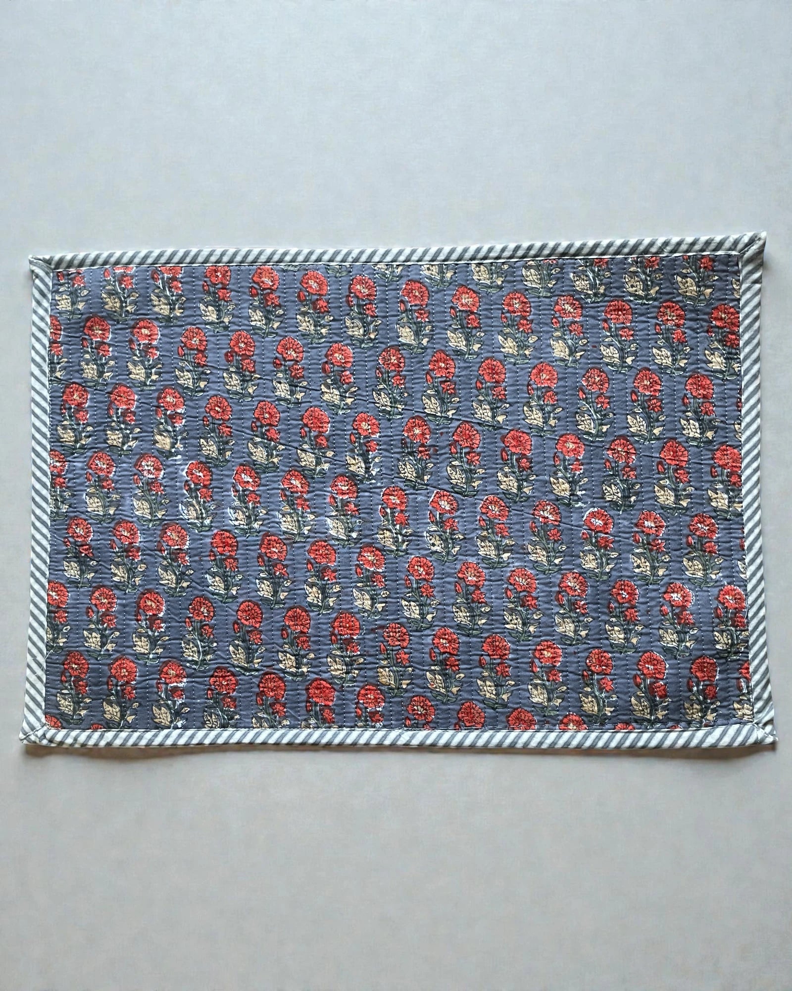 Coordinated set of scarlet and grey quilted cotton placemats on a table