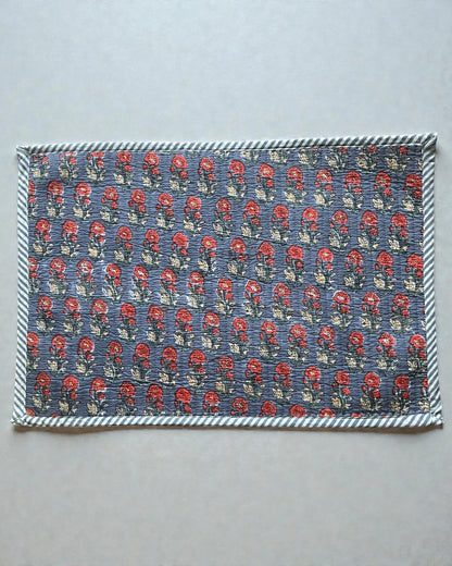 Coordinated set of scarlet and grey quilted cotton placemats on a table