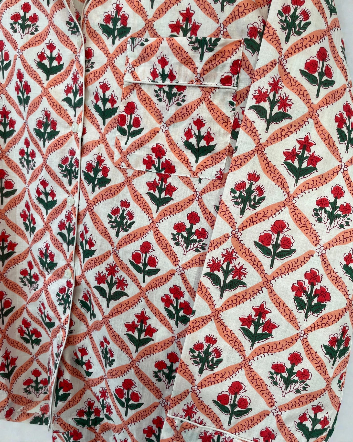 Close-up of scarlet red and coral pink floral print on 100% cotton pyjamas