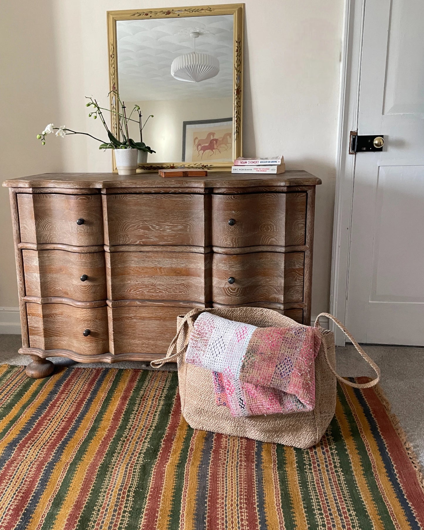 Sisal storage basket holding a folded textured blanket for stylish home organisation