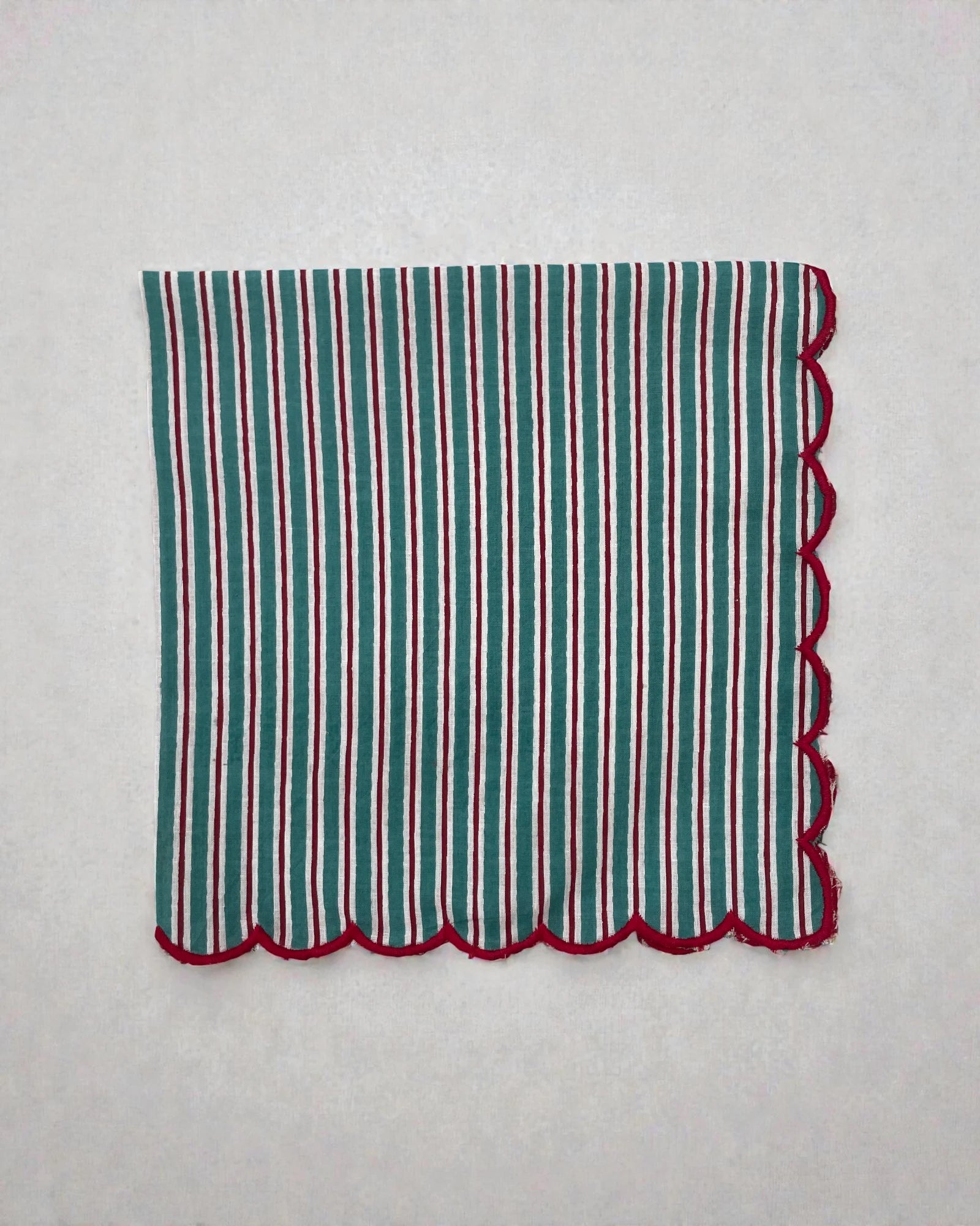 Cotton table napkin with teal stripes and scalloped red border