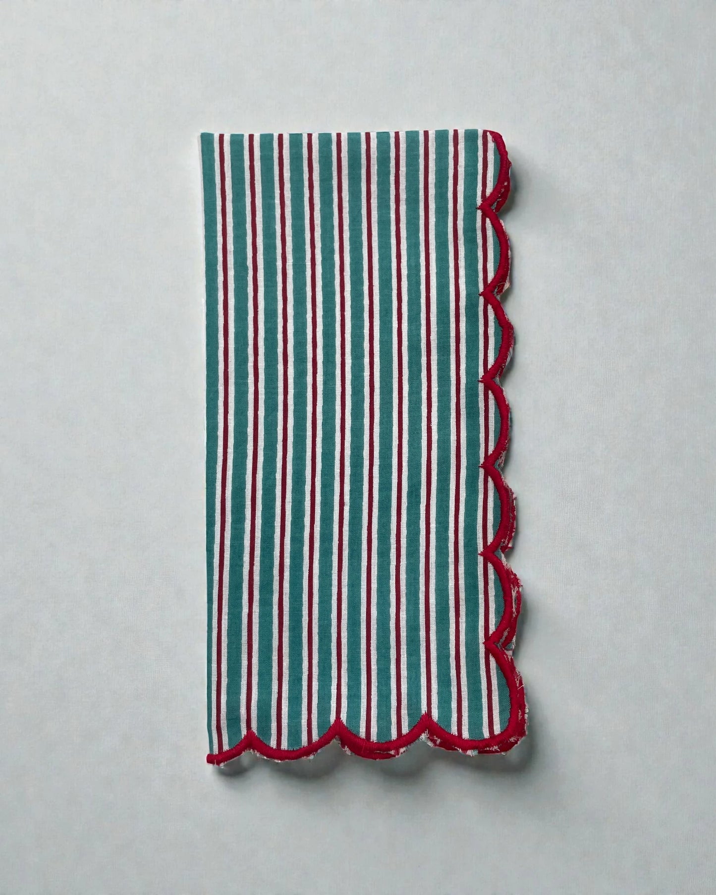 Teal and white striped cotton napkin with red scalloped edge