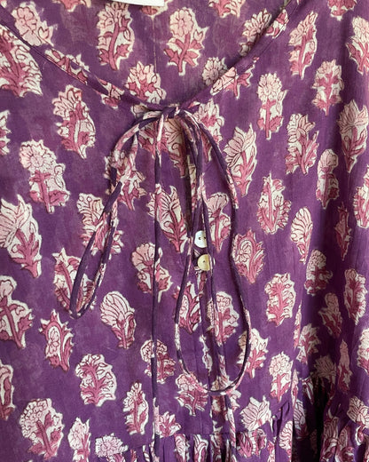 Close-up of the tie neckline and hand block printed cotton fabric  with mother of pearl buttons on the Amethyst mini dress