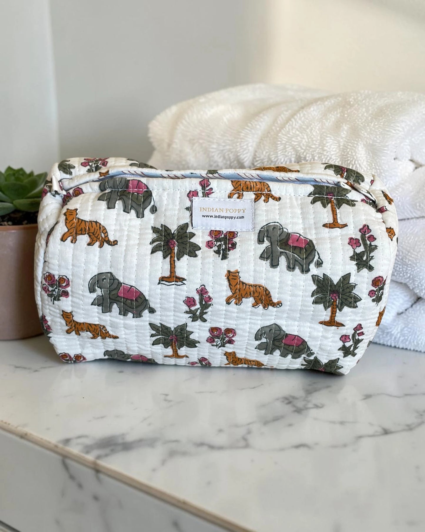 Fun, bright printed wash, toiletry and cosmetics bag displayed on a marble vanity, stylish giftable pouch for beauty essentials and travel accessories