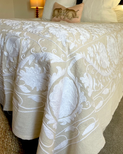 Hand embroidered suzani quilt with white stitching on natural linen fabric